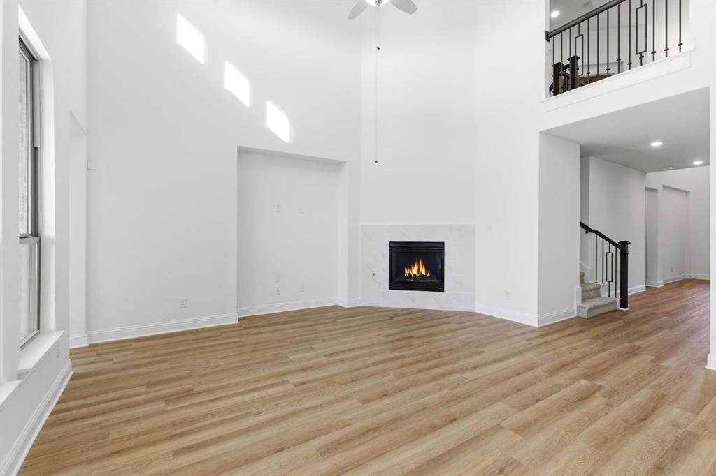 241 Bay Laurel Road McKinney, TX 75071 - Photo 18 of 32 a view of an empty room with wooden floor and a fireplace