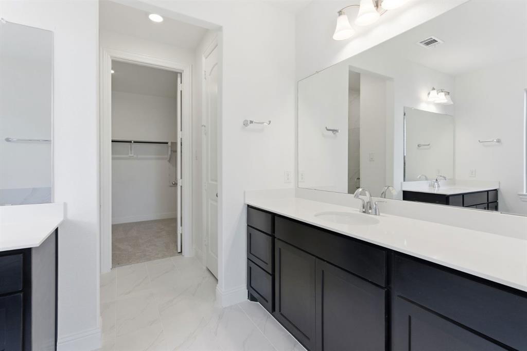 241 Bay Laurel Road McKinney, TX 75071 - Photo 26 of 32 a bathroom with a double vanity sink a mirror and a shower