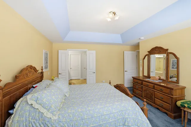 a bedroom with a bed and dresser with mirror