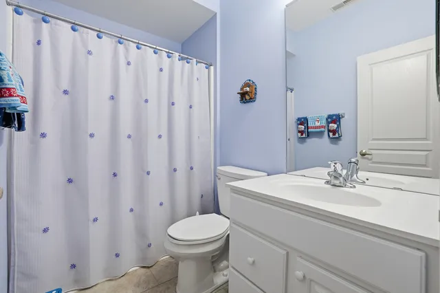 a bathroom with a sink a toilet and shower curtain