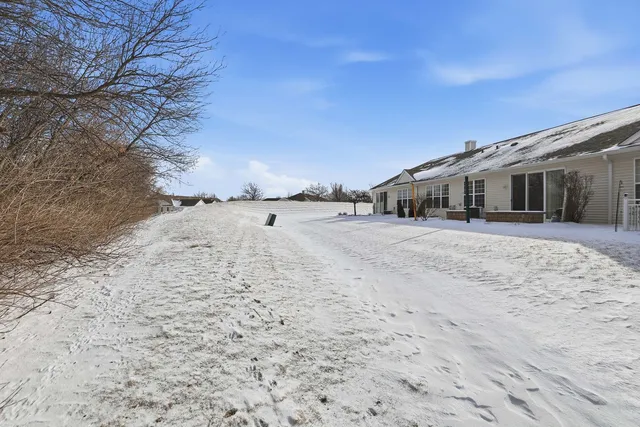 a view of a large white house with a yard covered in snow