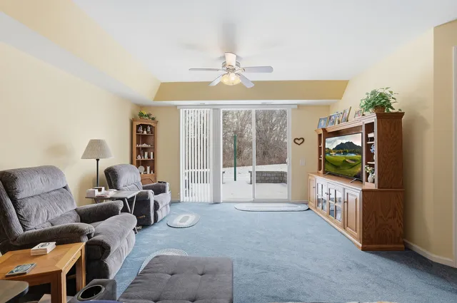 a living room with furniture a flat screen tv and a floor to ceiling window