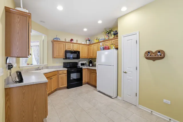 a kitchen with refrigerator a microwave a stove and a sink
