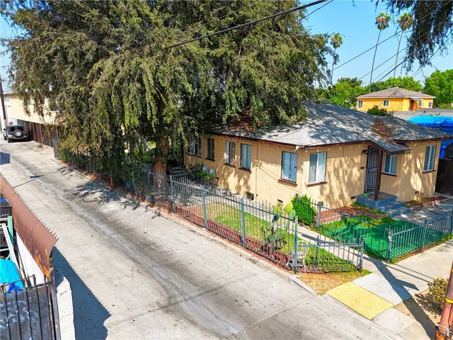 a view of a house with a backyard and a large tree
