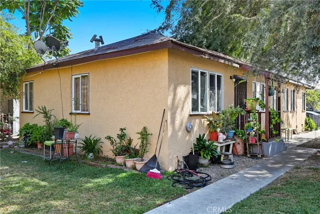 a view of a backyard with plants and a bench
