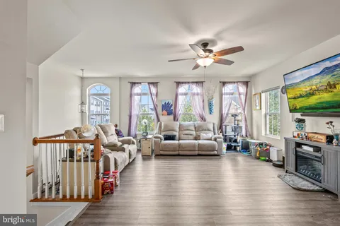 a living room with furniture floor to ceiling window and a flat screen tv