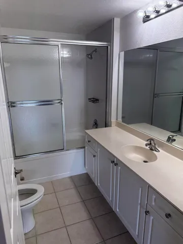 a bathroom with a double vanity sink toilet and shower