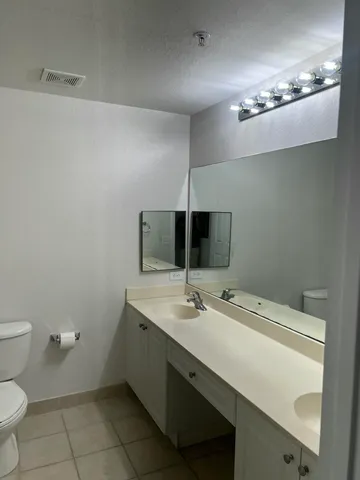 a bathroom with a sink a toilet and a mirror