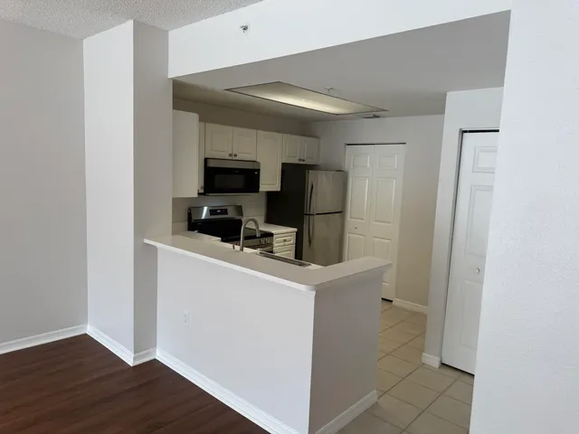 a kitchen with a refrigerator and a stove top oven