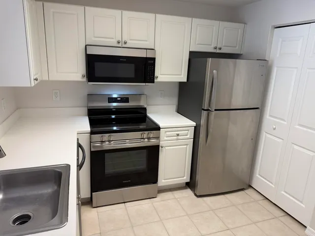 a kitchen with a refrigerator and a stove top oven
