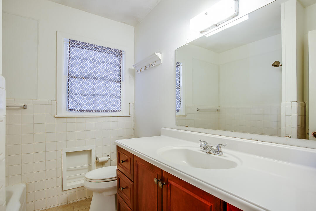 2802 54th Street Lubbock, TX 79413 - Photo 11 of 14 a bathroom with a granite countertop sink mirror vanity and toilet