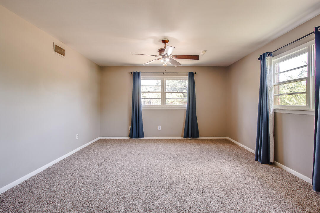 2802 54th Street Lubbock, TX 79413 - Photo 2 of 14 an empty room with windows and ceiling fan