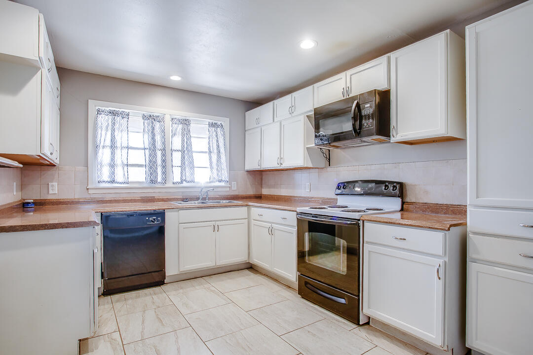 2802 54th Street Lubbock, TX 79413 - Photo 5 of 14 a kitchen with a sink stove top oven and microwave