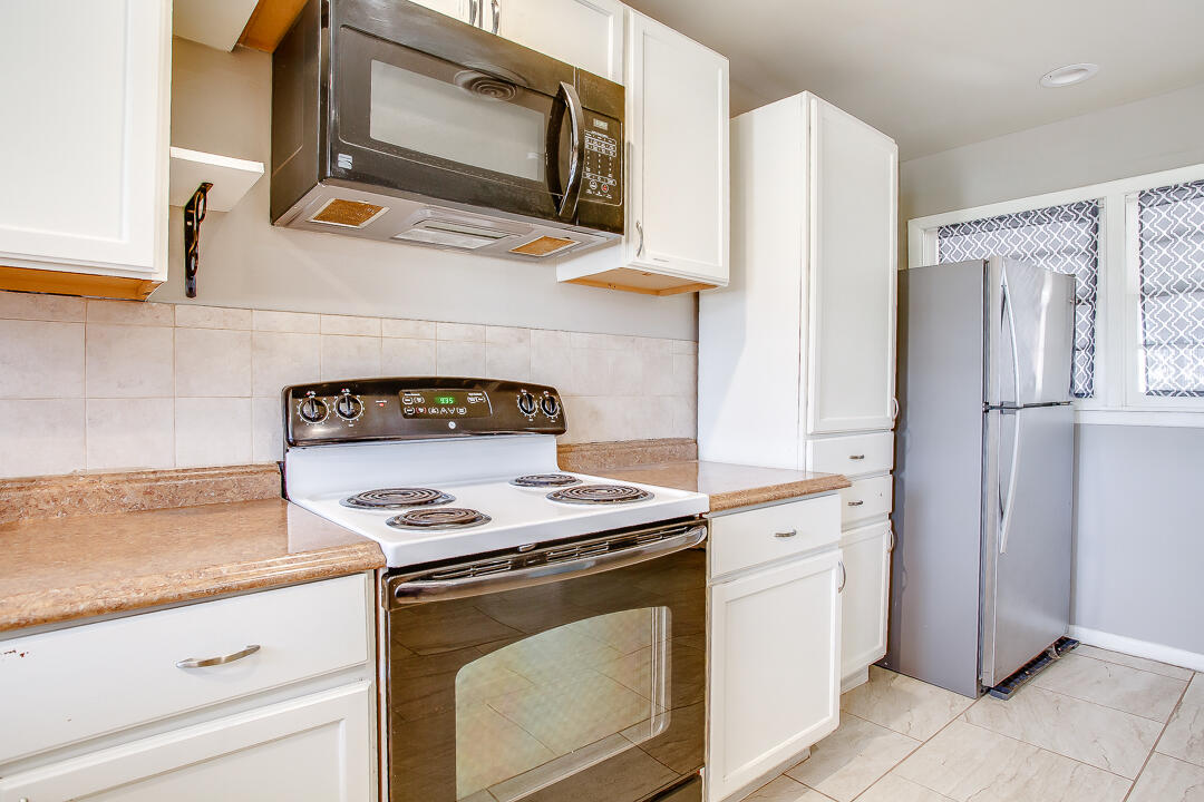 2802 54th Street Lubbock, TX 79413 - Photo 6 of 14 a kitchen with granite countertop cabinets stainless steel appliances and a counter space