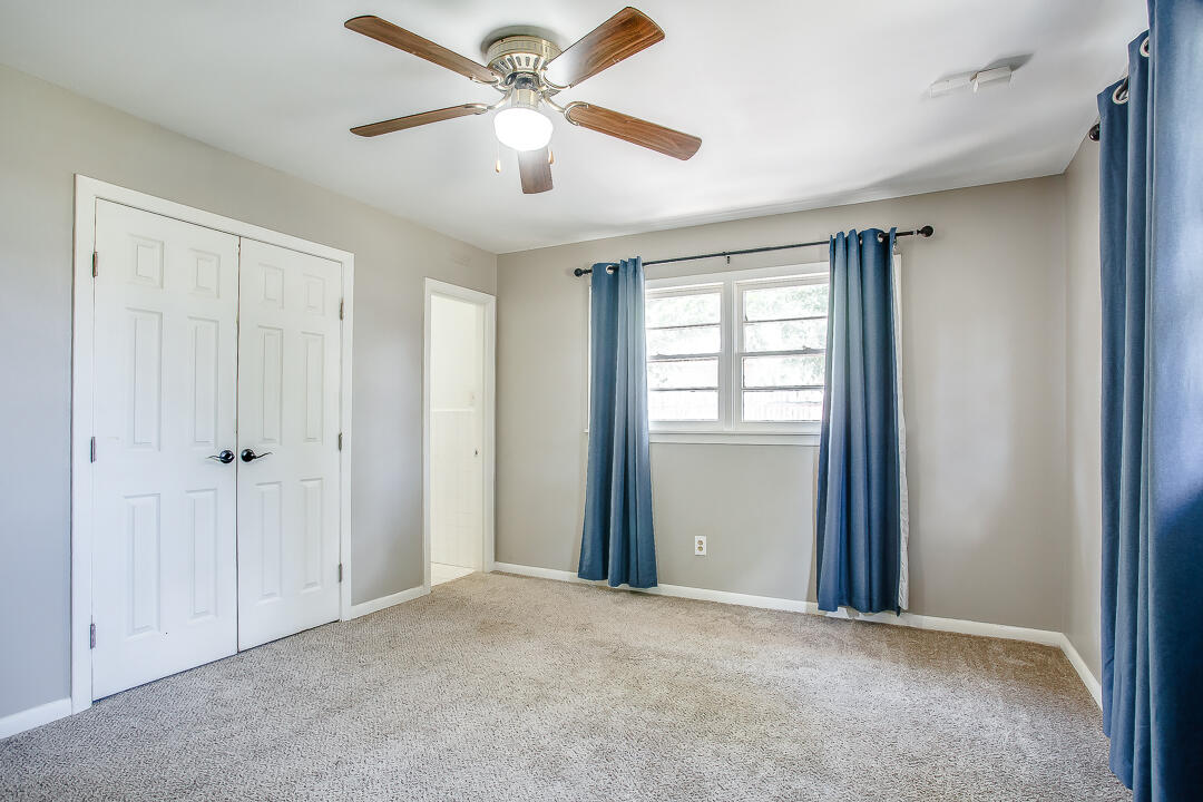 2802 54th Street Lubbock, TX 79413 - Photo 7 of 14 an empty room with chandelier fan and windows