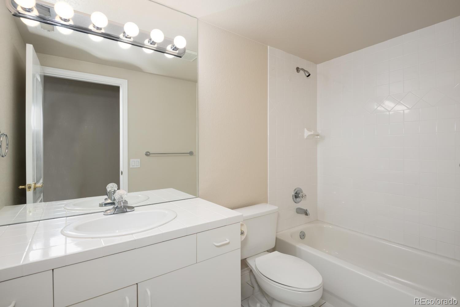 210 Cook Street Denver, CO 80206 - Photo 23 of 26 a bathroom with a sink a toilet and a mirror