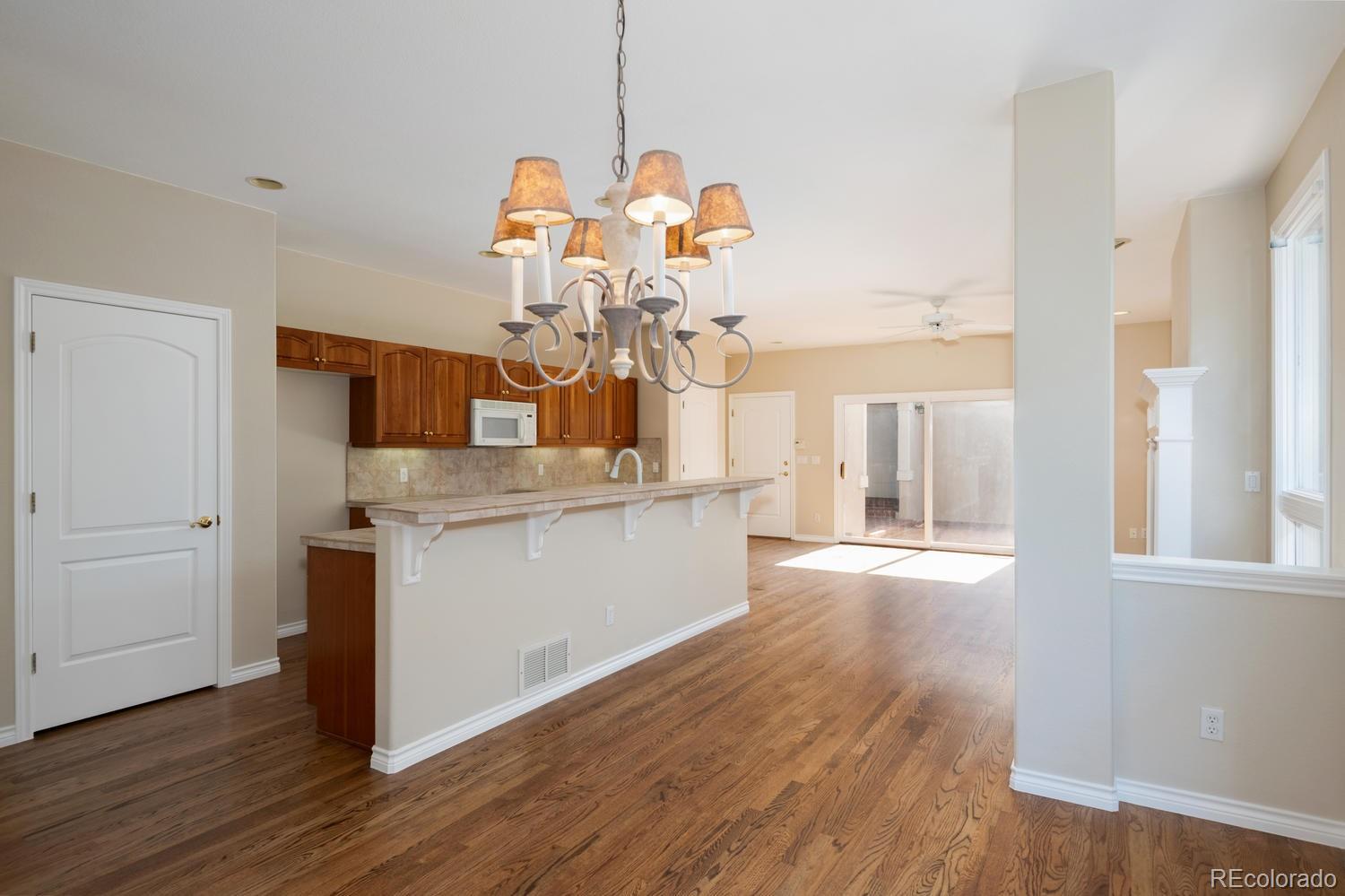 210 Cook Street Denver, CO 80206 - Photo 5 of 26 a dining room with granite countertop wooden floor and a chandelier