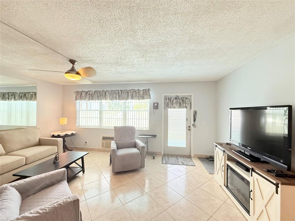 53 Markham C, Unit 53 Deerfield Beach, FL 33442 - Photo 4 of 30 a living room with furniture and a flat screen tv