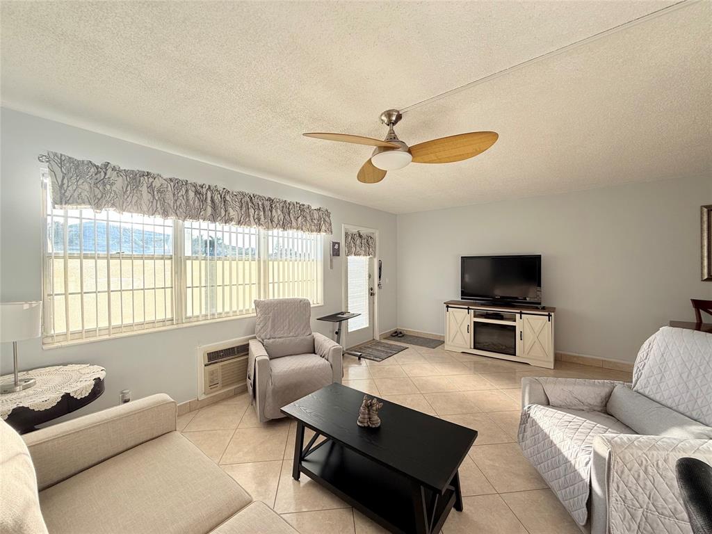53 Markham C, Unit 53 Deerfield Beach, FL 33442 - Photo 6 of 30 a living room with furniture a window and a flat screen tv