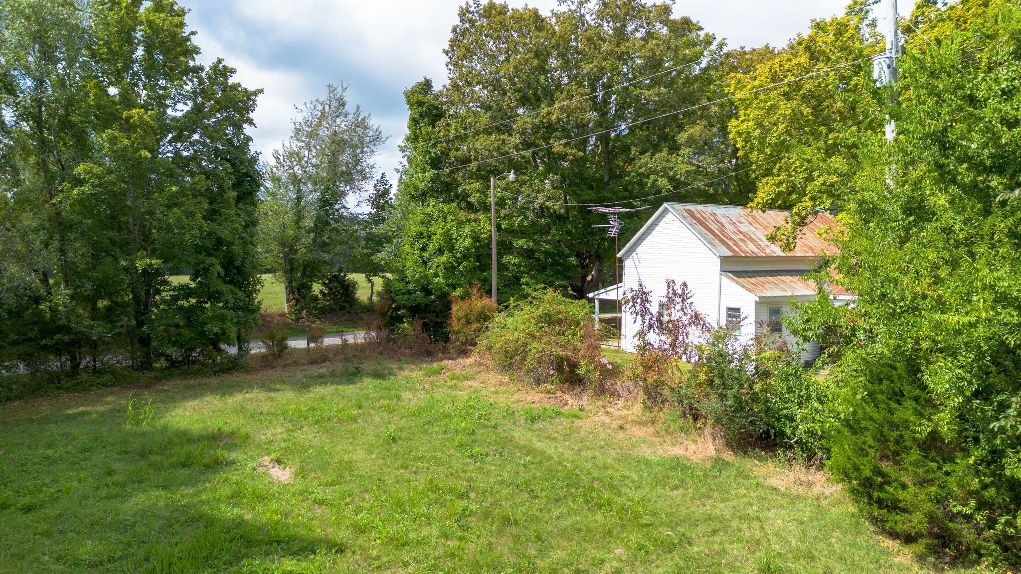 2882 Mobley Ridge Road Duck River, TN 38454 - Photo 41 of 70 a backyard of a house with lots of green space and fountain