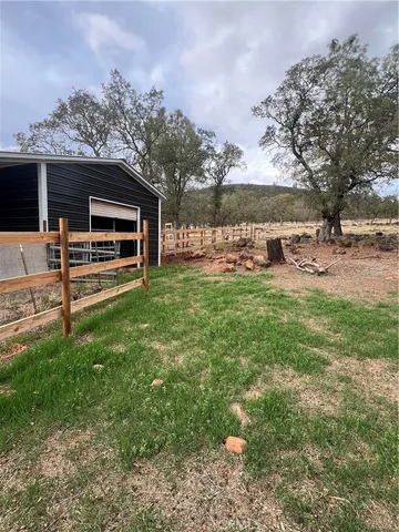 a view of a backyard with table and chairs under an umbrella