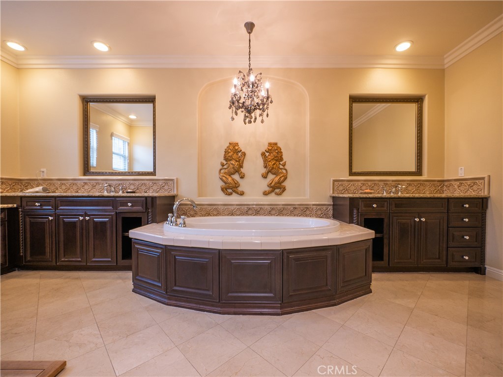 8111 Sunset Rose Drive Corona, CA 92883 - Photo 12 of 19 a spacious bathroom with a granite countertop sink a mirror and a bathtub