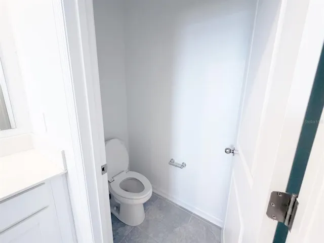 a white toilet sitting next to a shower