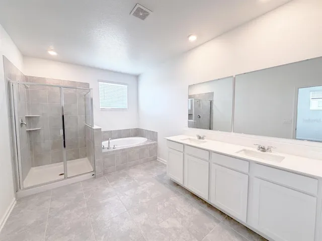 a bathroom with a granite countertop sink mirror and bathtub