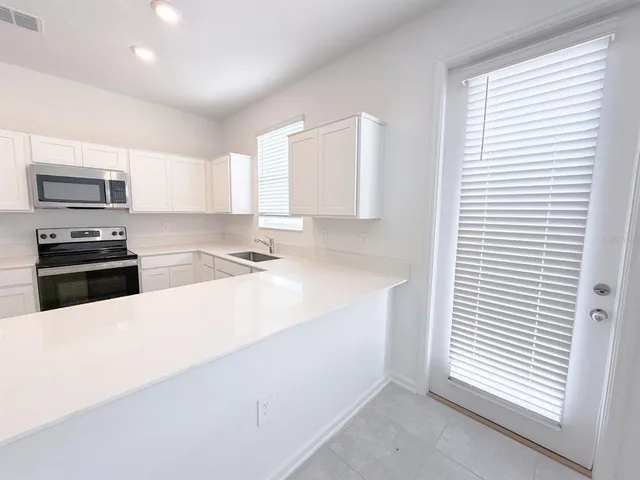 a kitchen with granite countertop a sink and a stove top oven