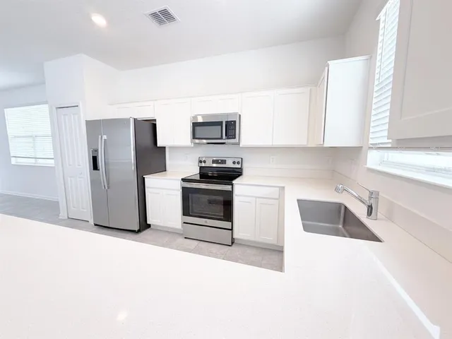 a kitchen with stainless steel appliances granite countertop a refrigerator sink and stove