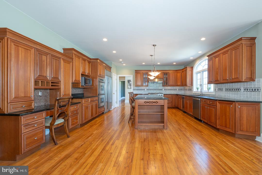 2 Spring Meadows Farm Lane Malvern, PA 19355 - Photo 11 of 63 a kitchen with stainless steel appliances kitchen island granite countertop wooden floors wooden cabinets and sink