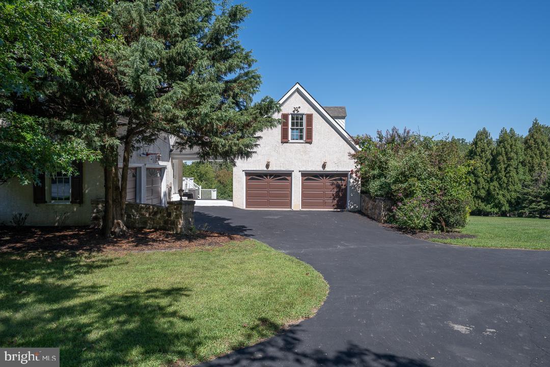 2 Spring Meadows Farm Lane Malvern, PA 19355 - Photo 57 of 63 a front view of a house with a yard and garage