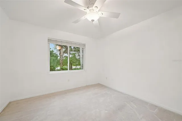 an empty room with a window and a fan