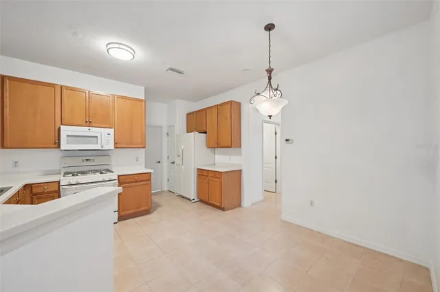 a kitchen with stainless steel appliances granite countertop a stove top oven a sink dishwasher and a refrigerator with wooden floor