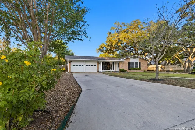 a front view of a house with a yard and trees