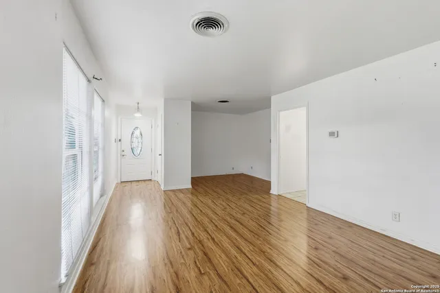 a view of empty room with wooden floor