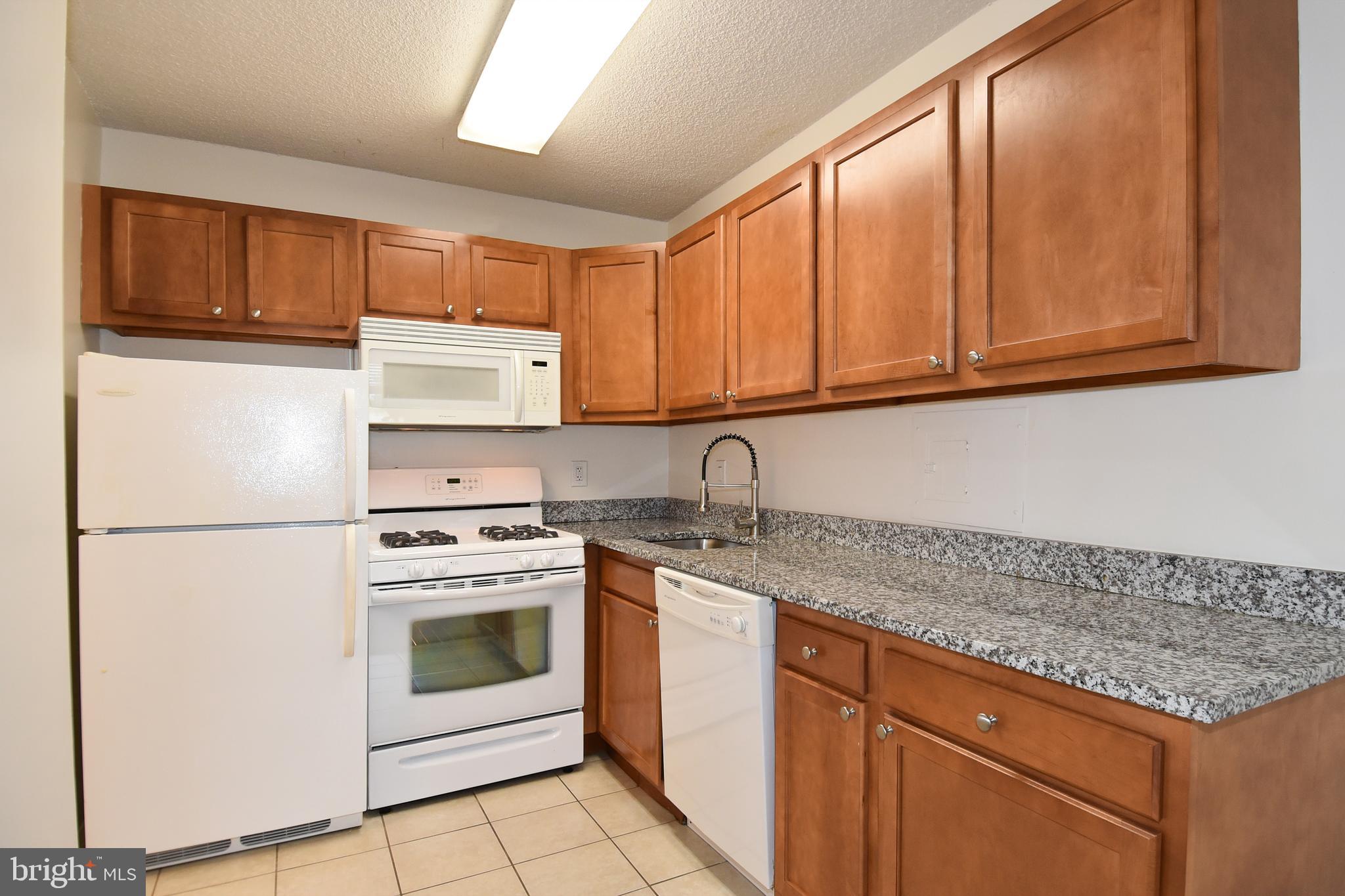 a kitchen with granite countertop cabinets stainless steel appliances and a sink