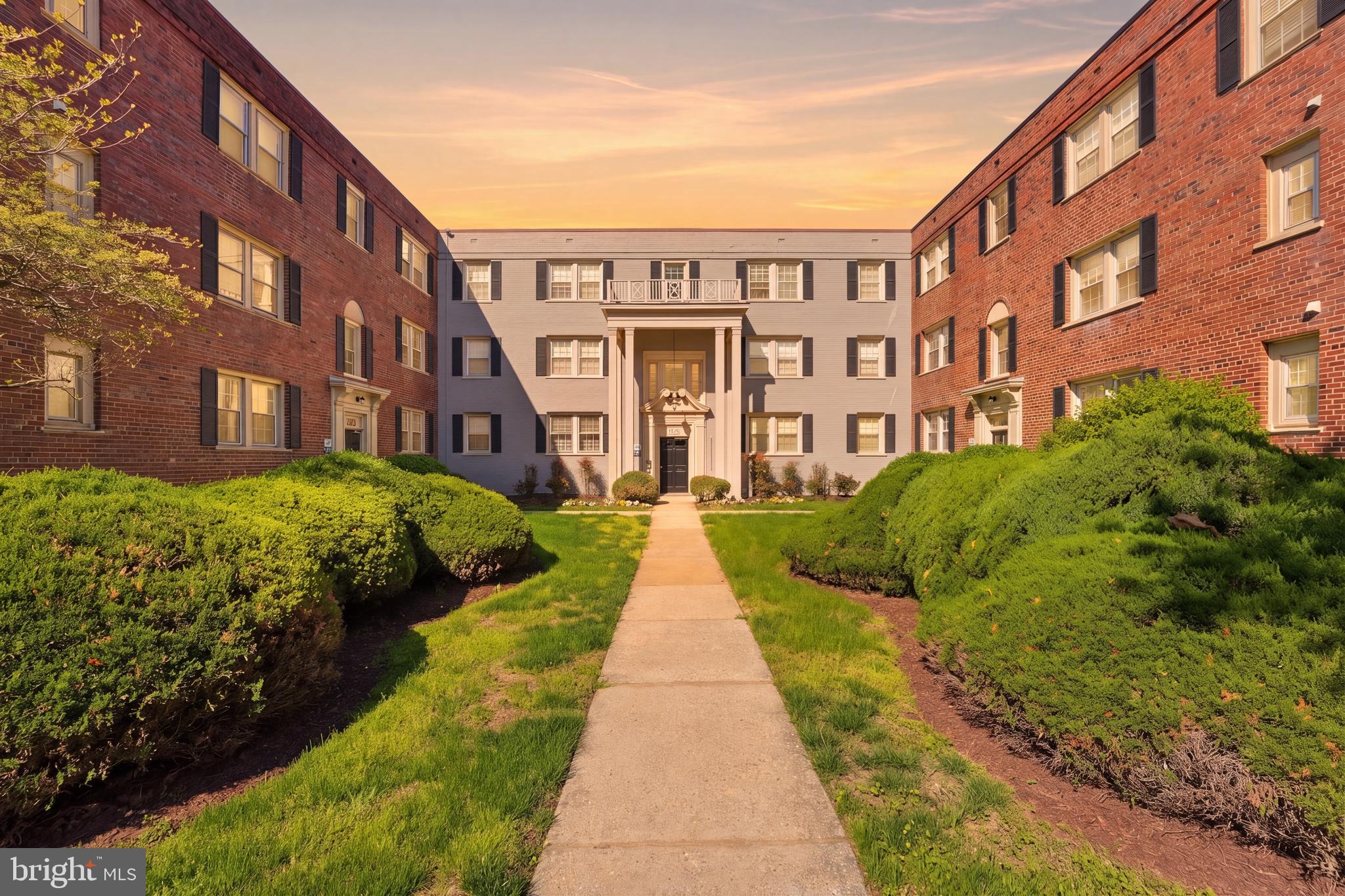 a view of a brick building next to a big yard