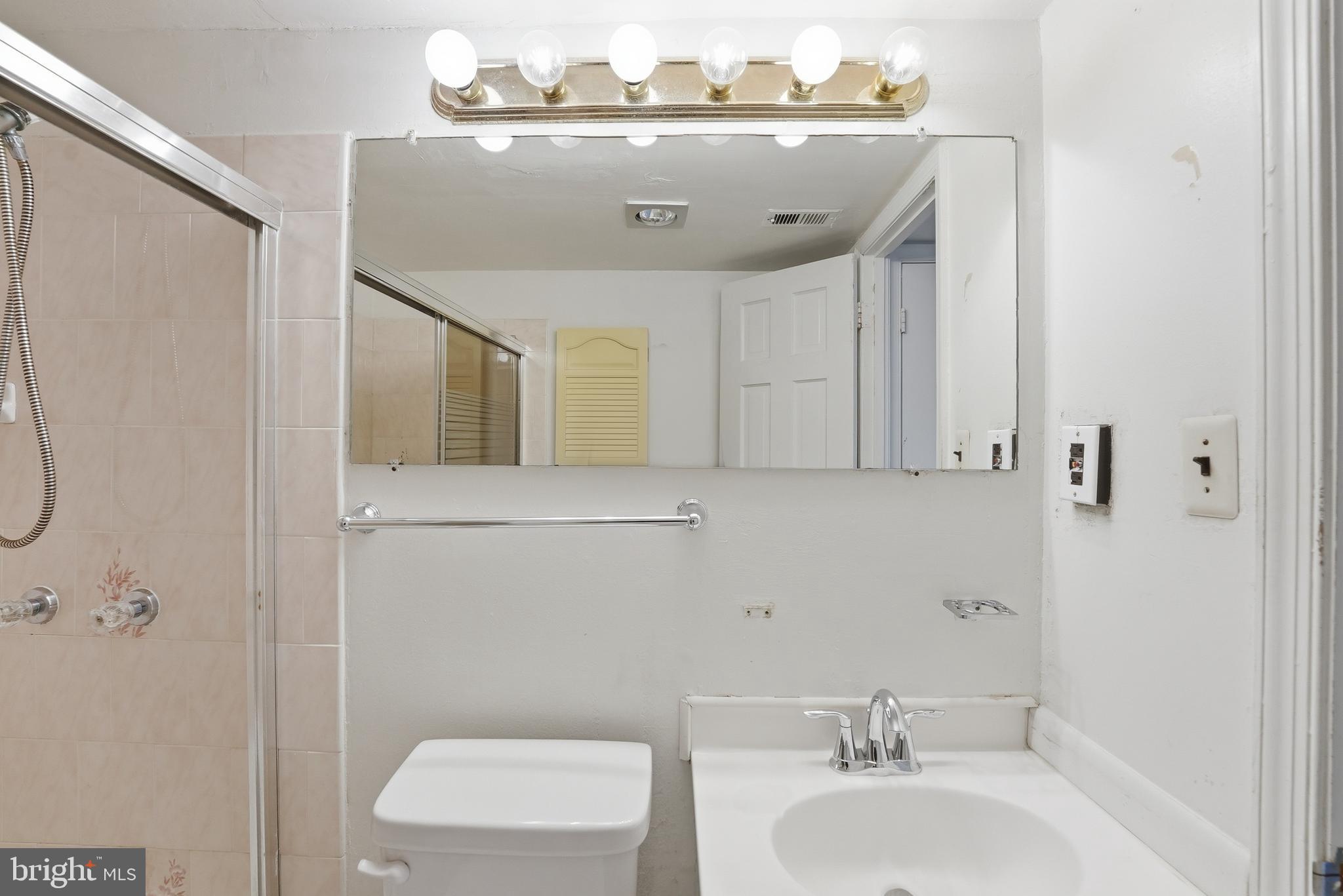 2011 37th Street Southeast, Unit 202 Washington, DC 20020 - Photo 17 of 24 a bathroom with a sink a toilet and mirror