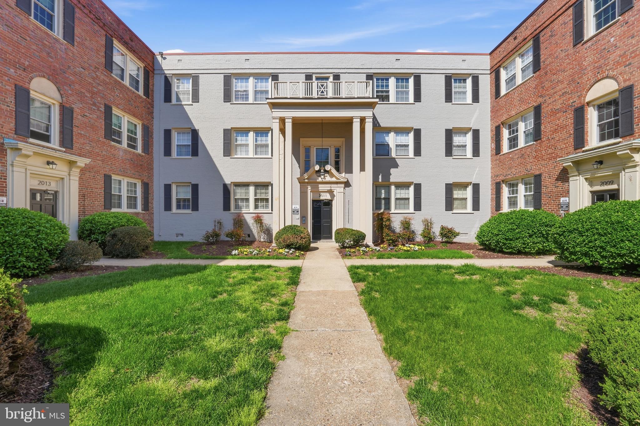 2011 37th Street Southeast, Unit 202 Washington, DC 20020 - Photo 22 of 24 a front view of a residential apartment building with a yard