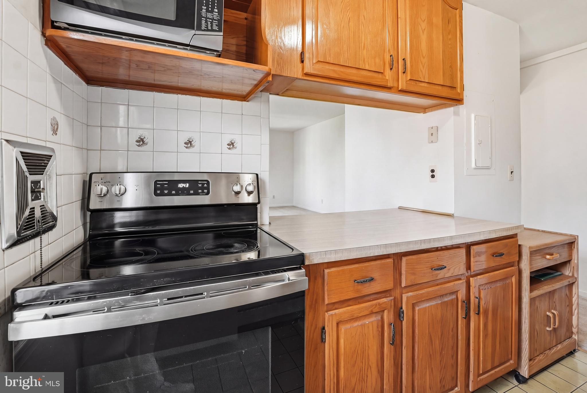 2011 37th Street Southeast, Unit 202 Washington, DC 20020 - Photo 6 of 24 a kitchen with wooden cabinets and a stove top oven