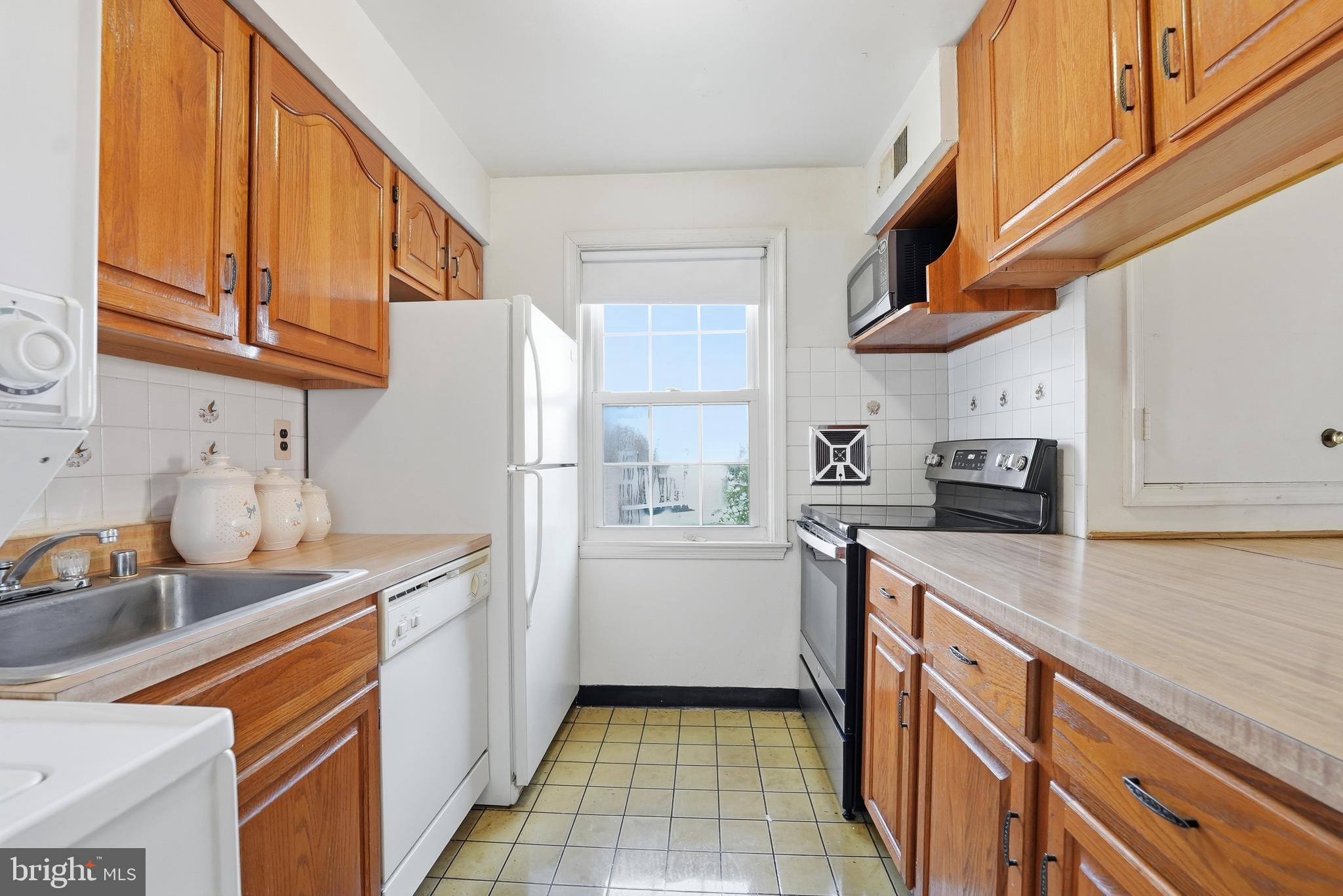 2011 37th Street Southeast, Unit 202 Washington, DC 20020 - Photo 8 of 24 a kitchen with stainless steel appliances granite countertop a sink stove and refrigerator