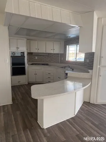 a kitchen with sink a microwave and cabinets
