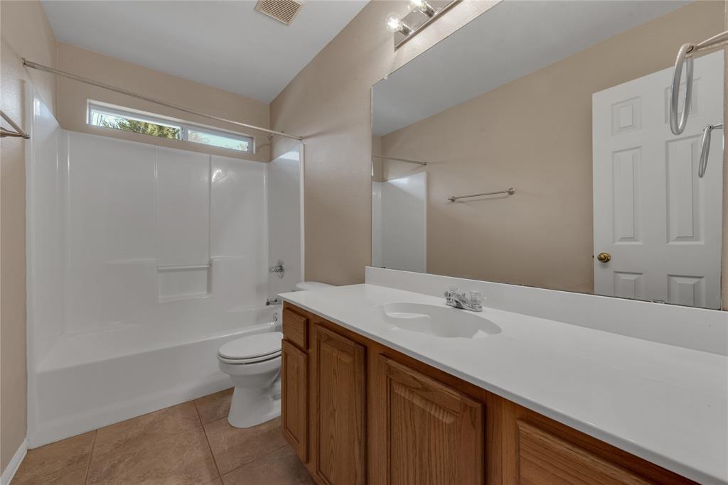 910 Derby Court Celina, TX 75009 - Photo 20 of 27 a bathroom with a sink a toilet and shower