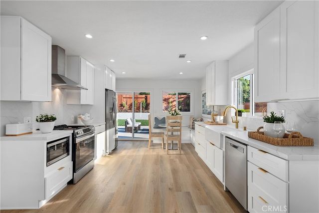 a large kitchen with stainless steel appliances granite countertop a lot of counter space and wooden floors
