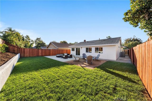 a view of a house with backyard and sitting area