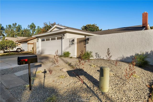 a view of a white house with a yard and sitting area