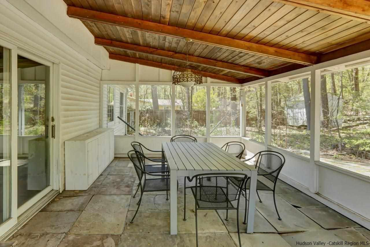 10 Pine Tree Road West Hurley, NY 12491 - Photo 24 of 28 a view of a patio with table and chairs and couches with wooden roof and stairs