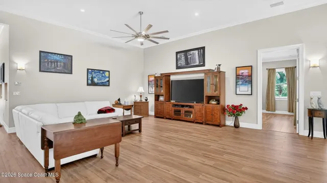 a living room with furniture a flat screen tv and a floor to ceiling window