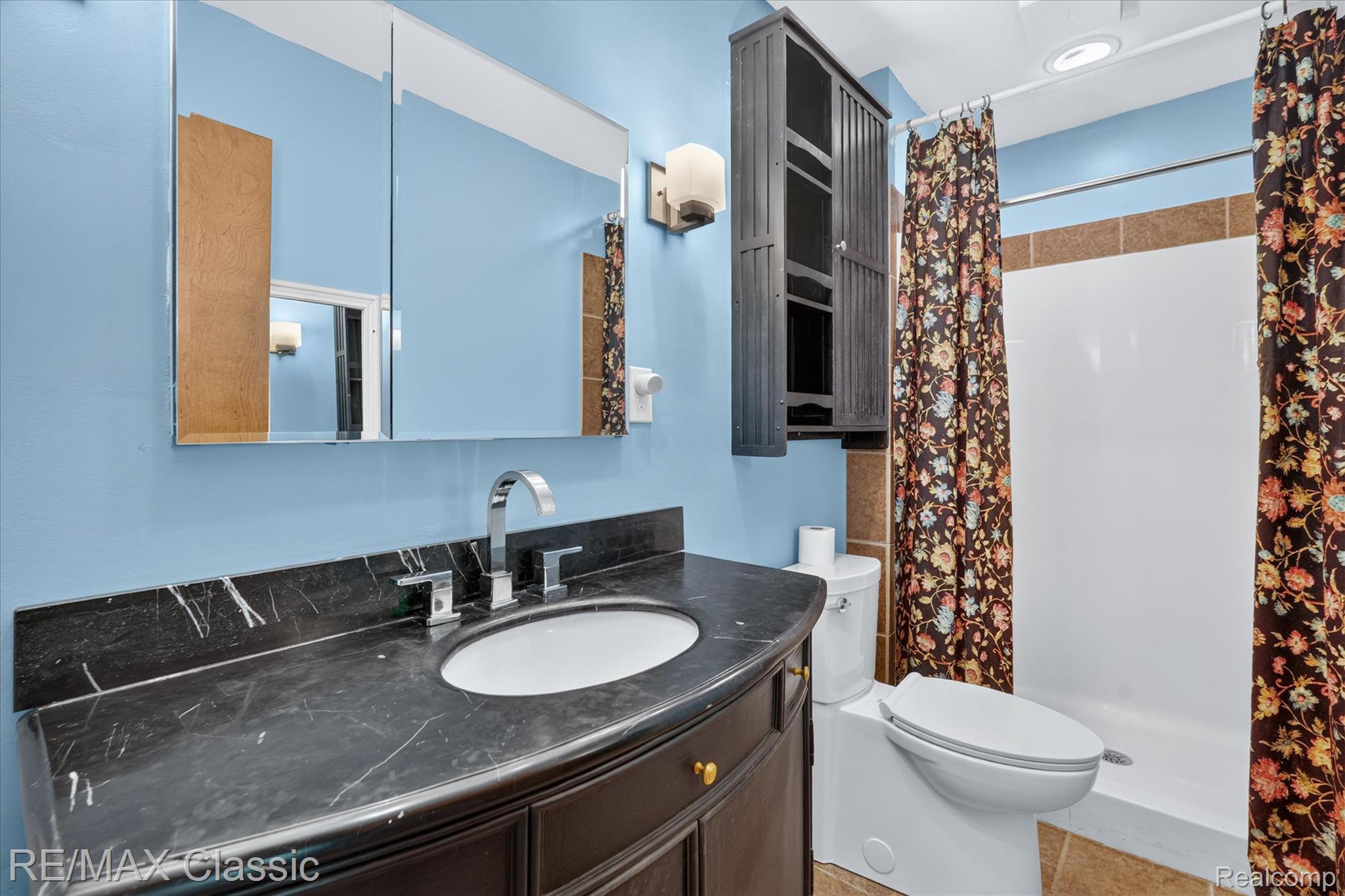 12189 Gage Road Holly, MI 48442 - Photo 21 of 69 Bathroom vanity featuring a dark countertop and a white oval sink with chrome fixtures